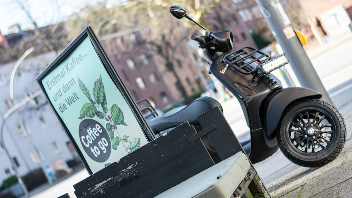 NEMO'S Roller mit Coffee-to-go-Schild vor dem Laden